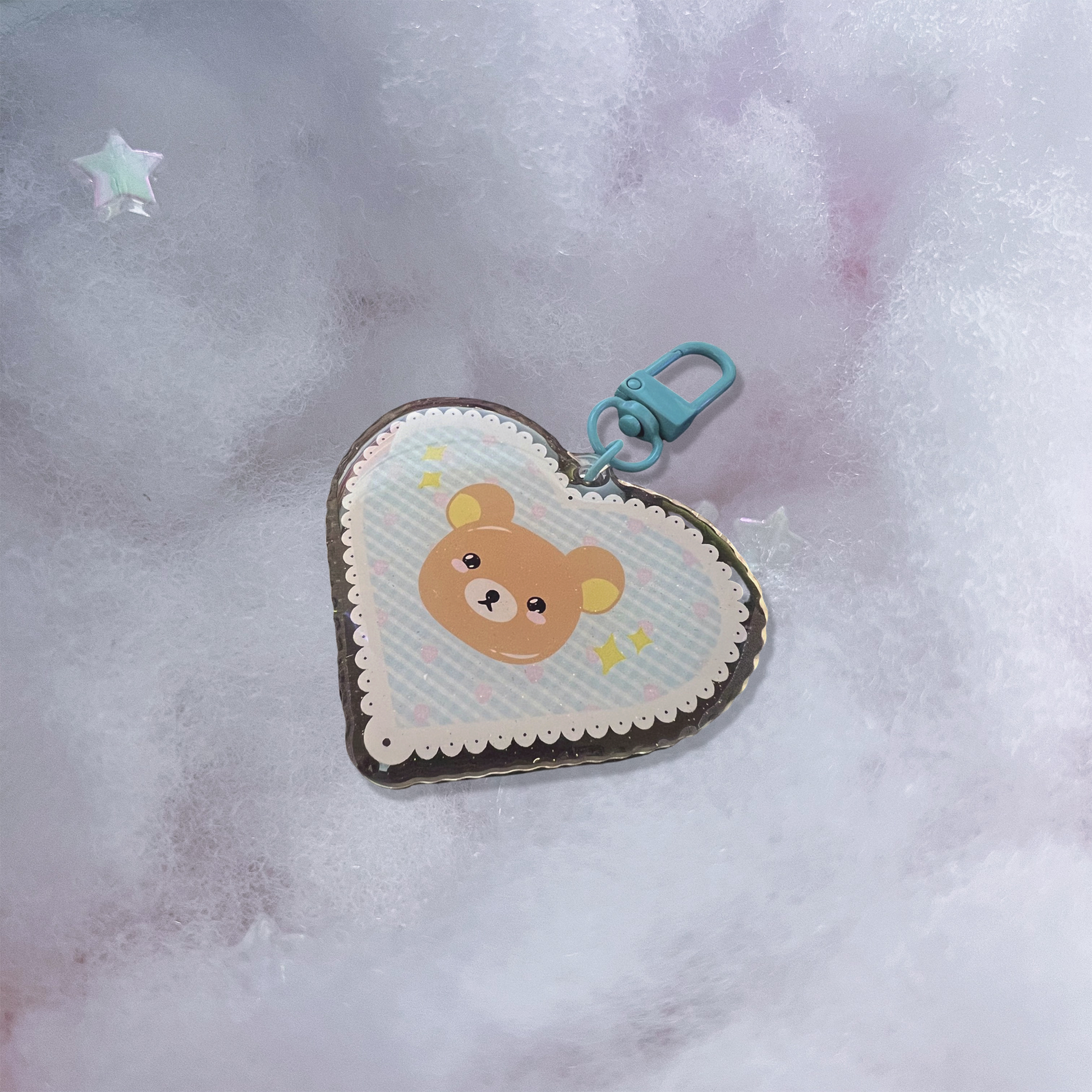 Brown bear acrylic keychain with micro-glitter finish and blue hook.