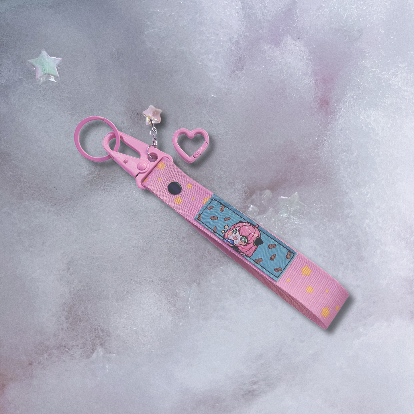 Anya Key Strap is a pink woven key strap with Anya Forger on a patch, with a star charm added and a heart carabiner attachment.