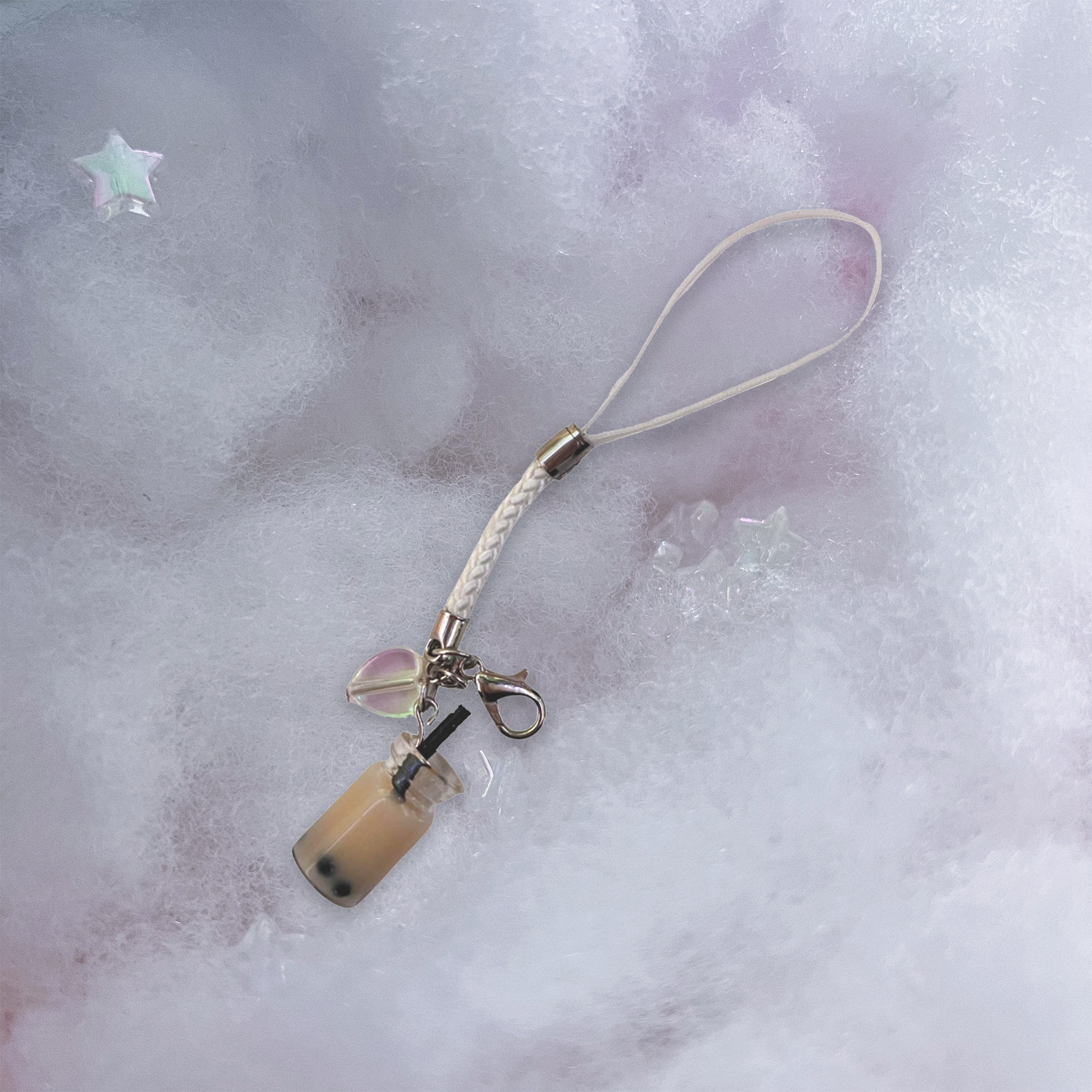 White boba charm with holographic heart charm and white braided phone strap.