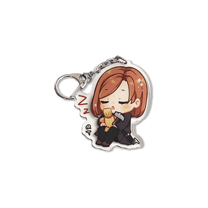 clear acrylic keychain featuring nobara kugisaki from jujutsu kaisen sleeping holding her cursed tools