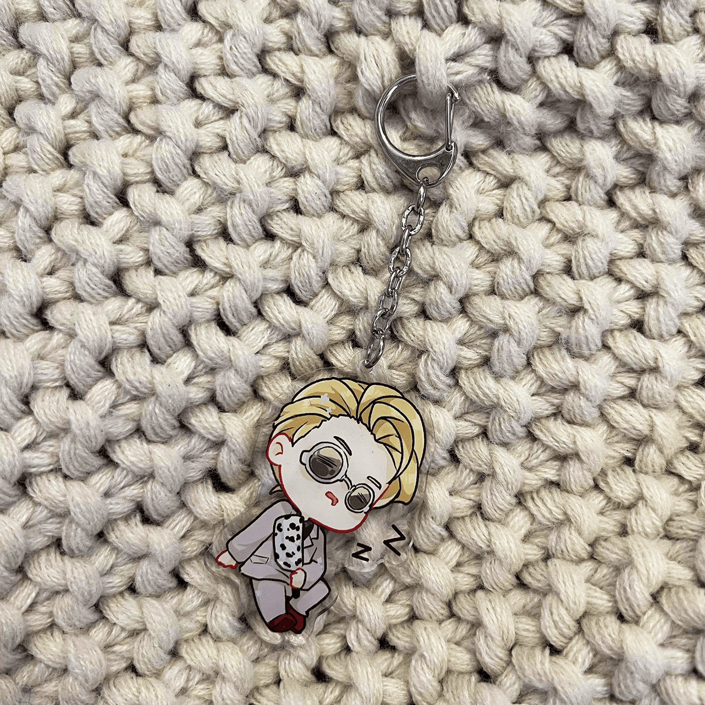 clear acrylic keychain featuring nanami kento from jujutsu kaisen sleeping holding his cursed weapon