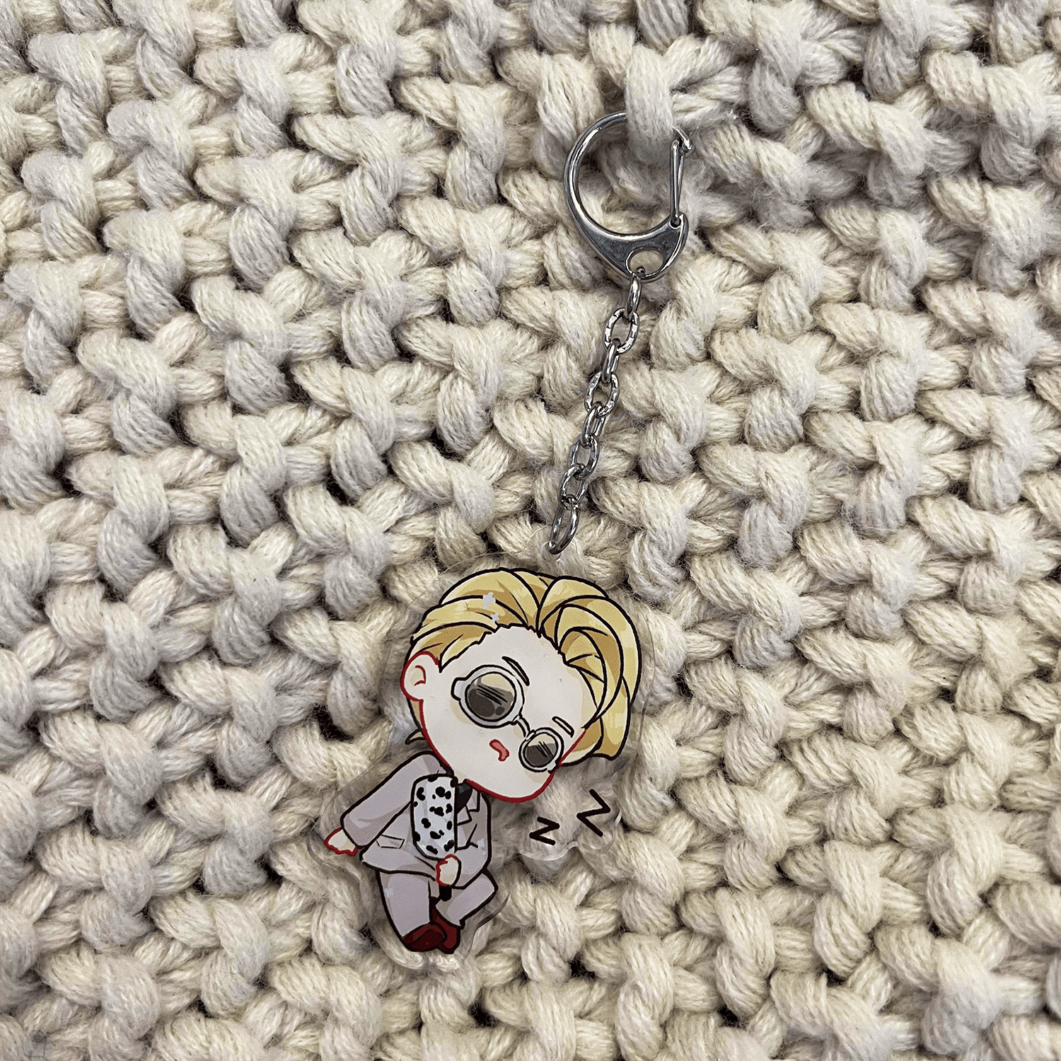 clear acrylic keychain featuring nanami kento from jujutsu kaisen sleeping holding his cursed weapon