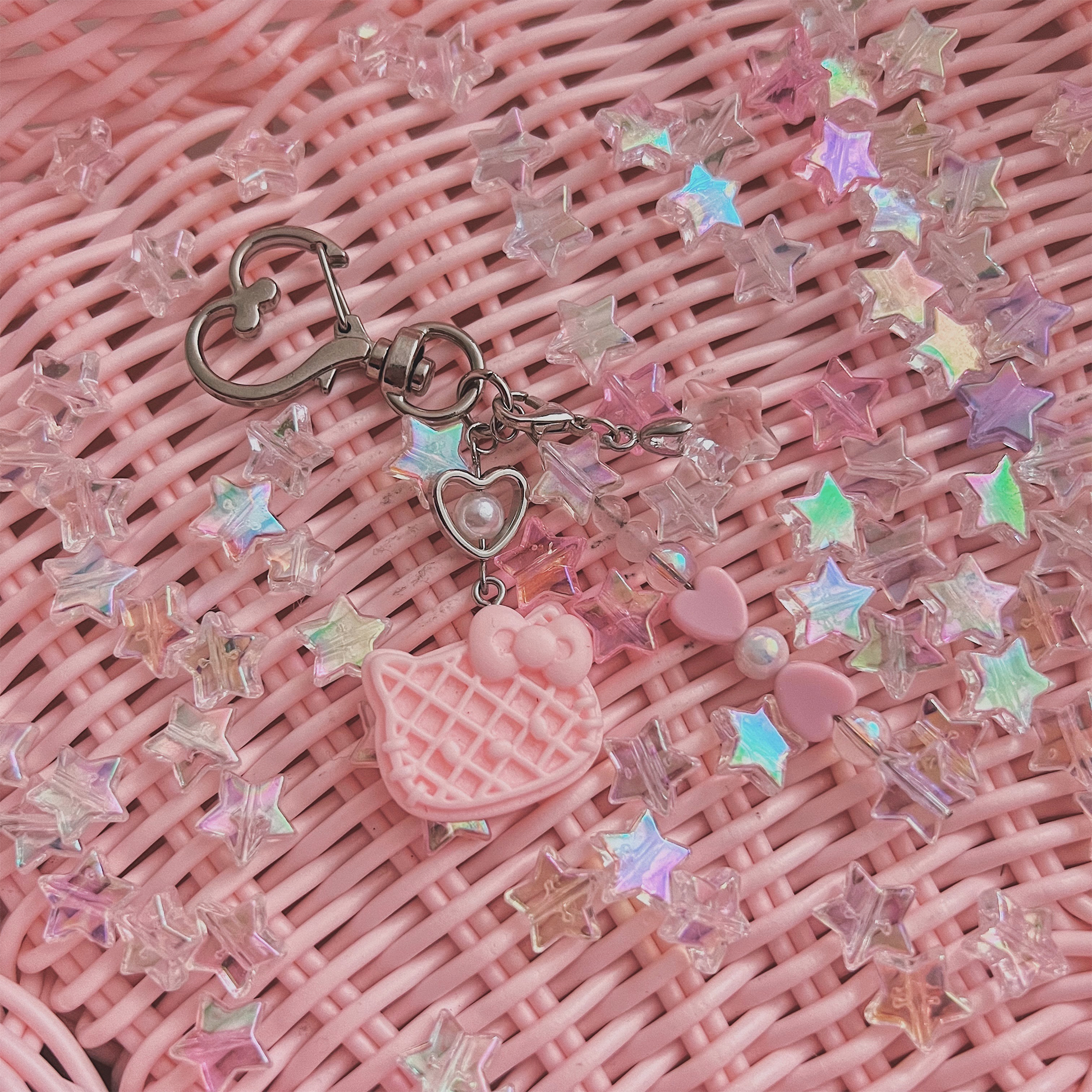 Pink Hello Kitty Waffle Charm specialty keychain with pink weaved basket background with holographic stars.