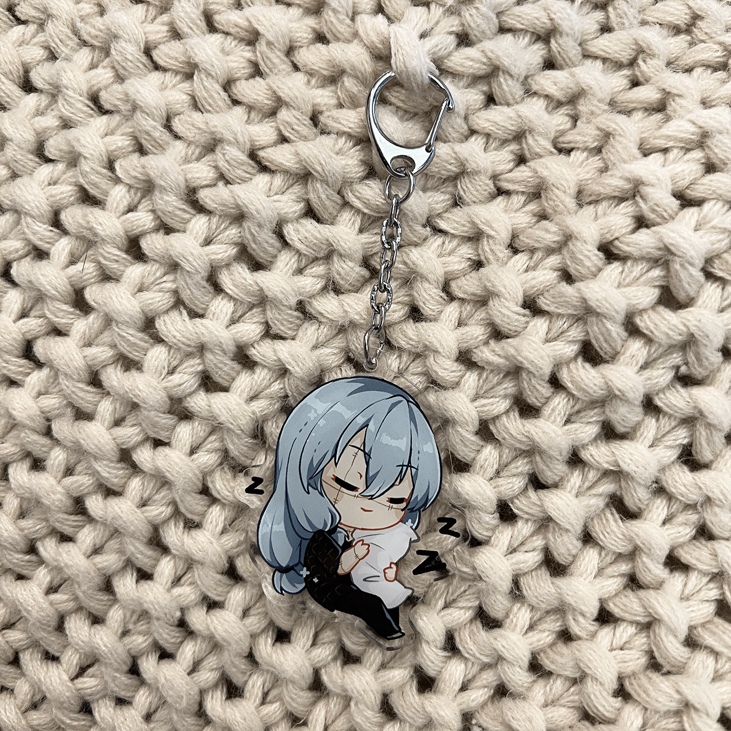 clear acrylic keychain feautring mahito from jujutsu kaisen sleeping holding a white pillow