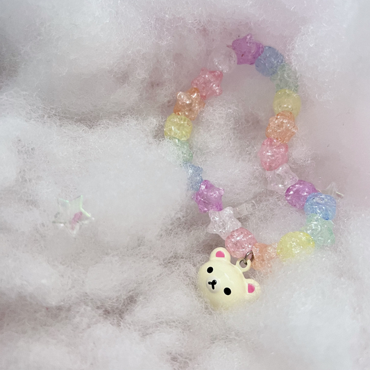 White Bear Trinket Charm on a pastel star bracelet, with a dreamy white fluffy cloud background.