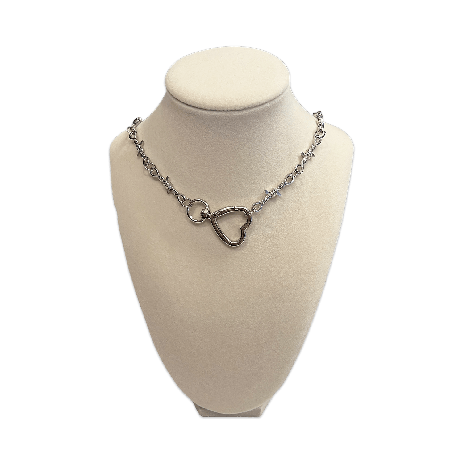 soft but deadly collection necklace featuring silver barbed wire and silver heart hook pendant on a white display stand