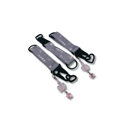 Soft but deadly key straps feature black metal detailing and black heart carabiner, with special bow keychain attached, and strap featuring "soft but deadly" text on a light grey pattern.
