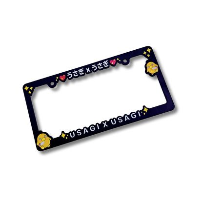 Psyduck License Plate features black plastic license plate with brand logo in Japanese characters and English text, 'USAGI X USAGI' with yellow sparkles and two Psyduck with Knife characters on each respective side.