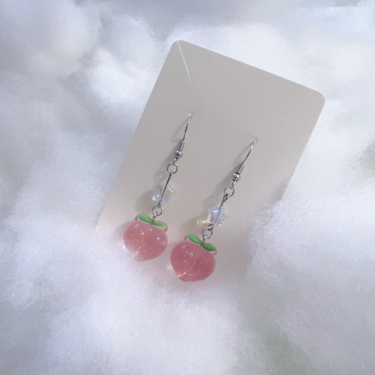 Glittery pink peach earrings with clear star bead accents.